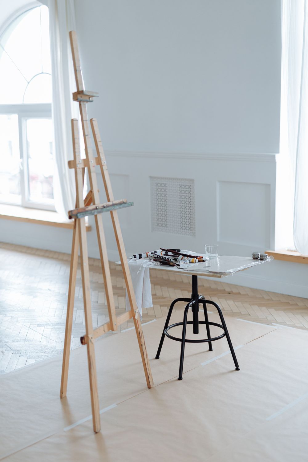 Heller Raum mit Holzstaffelei, Hocker und einem Tisch mit Zeichenmaterial